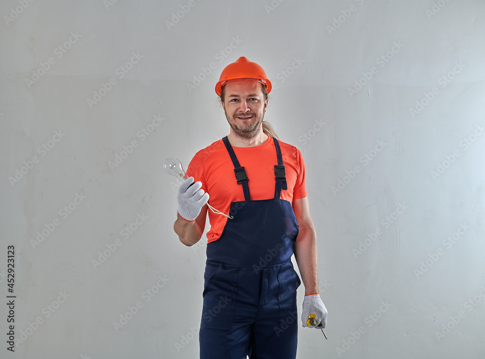 a new light bulb in the hands of a professional electrician a new light bulb in the hands of a professional electrician
