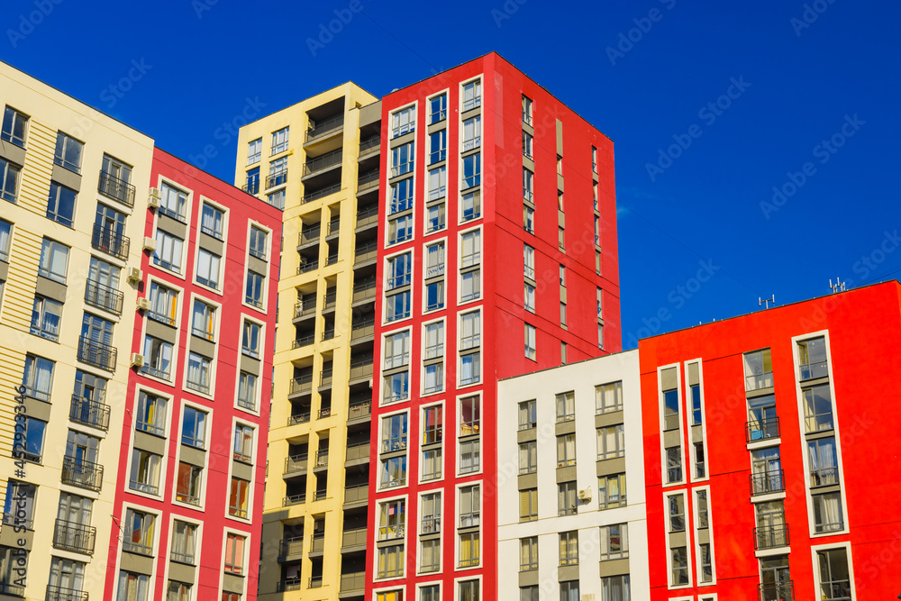 modern apartment architecture estate complex building red white and yellow facade wall in clear weather time and blue sky background development idea