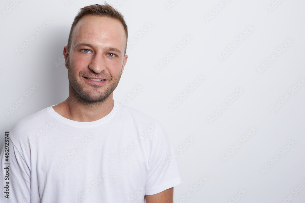 Man smiling in a white background with white t-shirt Man smiling in a white background with white t-shirt