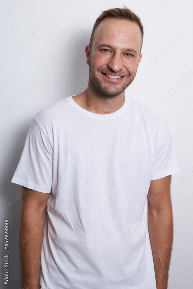 Man smiling in a white background with white t-shirt