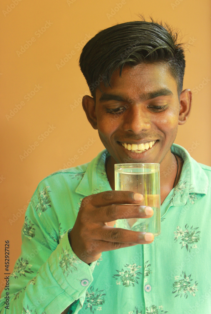 Young Indian rural boy holding a glass of clean drinking water Young Indian rural boy holding a glass of clean drinking water