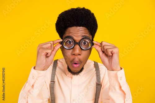 Photo portrait man in shirt wearing spectacles checking eyesight amazed isolated bright yellow color background