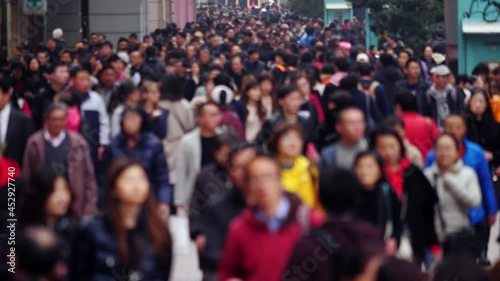 Busy pedestrian street of Chinese city, blurred view on crowd of walking people. Popular shopping and touristic area of Shanghai at day time, alley full of unrecognizable domestic people and visitors
