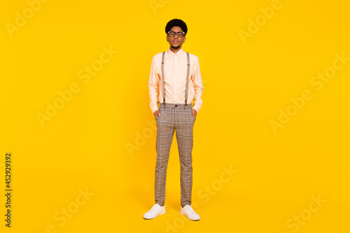 Full length body size photo man serious wearing stylish outfit glasses isolated vivid yellow color background