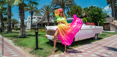 Summer fashion. Beautiful sexy blonde woman in colorful dress near the pink car on Cuba Havana. Spring and summer fashion model concept. Vintage and retro style. Luxury travel. © marcink3333