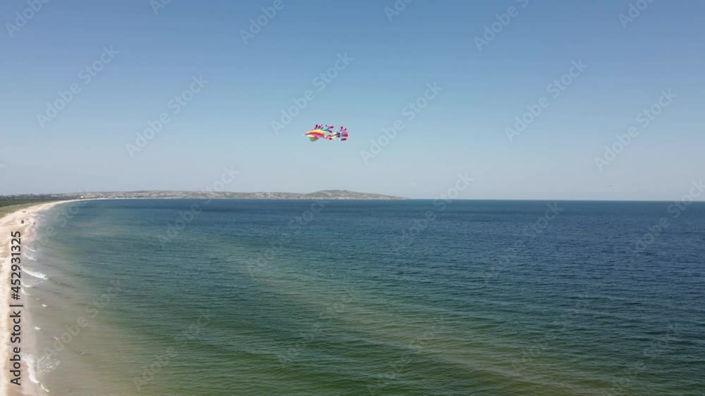 rainbow a multicolored kite flies over the sea in summer taken on drone rainbow a multicolored kite flies over the sea in summer taken on drone