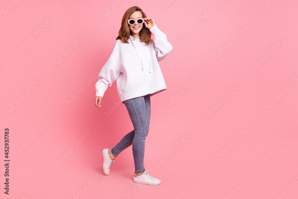Full length body size view of charming cheerful girl walking touching specs isolated over pink pastel color background Full length body size view of charming cheerful girl walking touching specs isolated over pink pastel color background