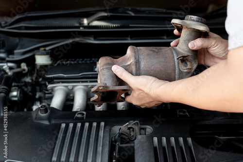 Foto Close up old catalytic converter in hand Technician remove from engine gasoline