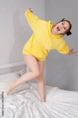happy positive brunette in yellow hoodie in bright room. happy people. millennial generation. fashionable teenager. trendy colours