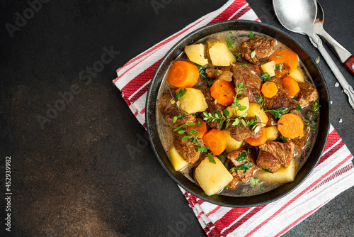 Traditional Irish stew in a black bowl on a dark background. Stew of lamb, potatoes, onions, carrots, and thyme. Traditional dish of St. Patrick's Day.