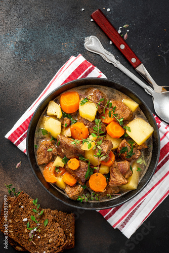 Traditional Irish stew in a black bowl on a dark background. Stew of lamb, potatoes, onions, carrots, and thyme. Traditional dish of St. Patrick's Day.