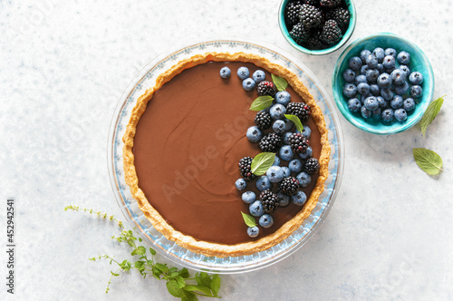Dark chocolate mousse tart decorated with fresh blueberries and mint