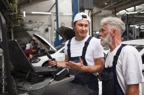 Wallpaper Mural Car service repairmen doing computer diagnostics at the garage Torontodigital.ca