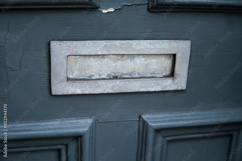 Old letterbox in the door, traditional way of delivering letters to the house, old mailbox, correspondence