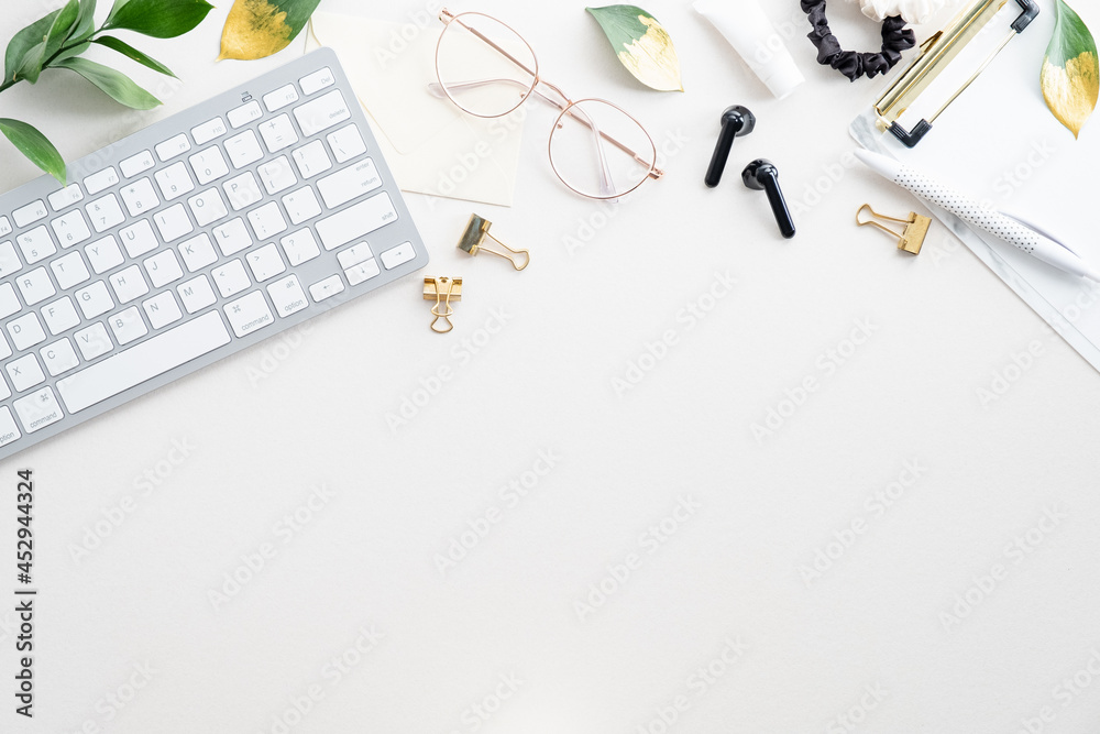 Elegant feminine workspace with keyboard, glasses, office supplies on white background. Minimal style. Flat lay, top view, copy space. Elegant feminine workspace with keyboard, glasses, office supplies on white background. Minimal style. Flat lay, top view, copy space.