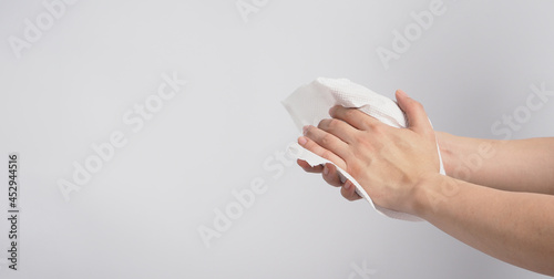 Obraz na plátně Hand is wiping tissue paper on white background.