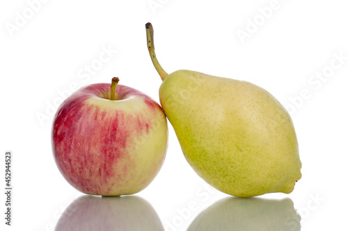 One juicy organic apple and one green pear, close-up, isolated on white.
