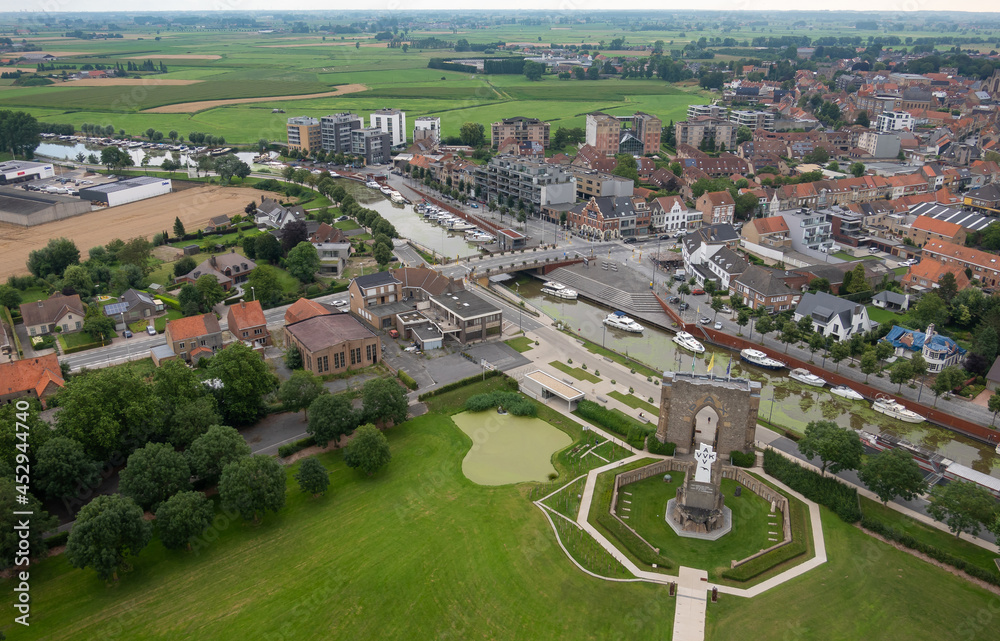 Diksmuide, Flanders, Belgium - August 3, 2021: IJzertoren domain. Aerial landscape showing agriculture, large part of town, the IJzer river with boats, and the Pax gate with crypt.