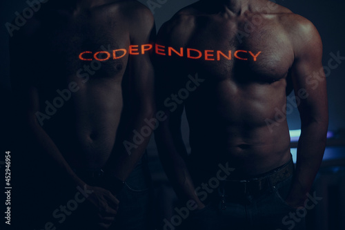 Man couple standing together with Codependency word oh his body.