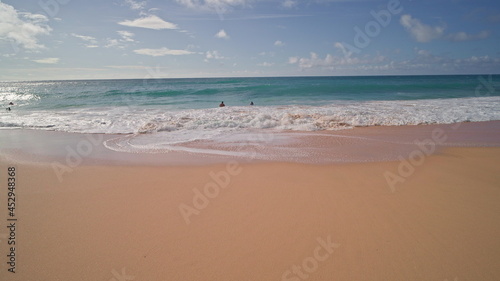 People swim in the ocean. Yellow sand at Sandy Beach on the tropical island of Oahu Hawaii. The turquoise color of the Pacific Ocean water. Steadicam shooting.