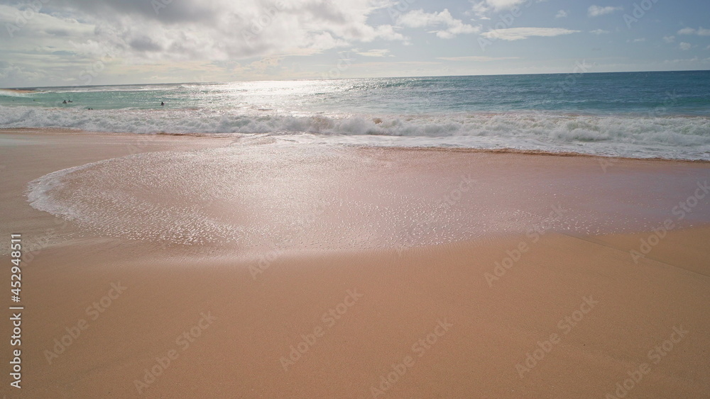 People swim in the ocean. Yellow sand at Sandy Beach on the tropical island of Oahu Hawaii. The turquoise color of the Pacific Ocean water. Steadicam shooting.