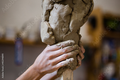 Female hands create a clay sculpture 