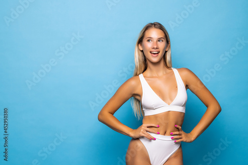 Beautiful slim woman body isolated on blue background photo