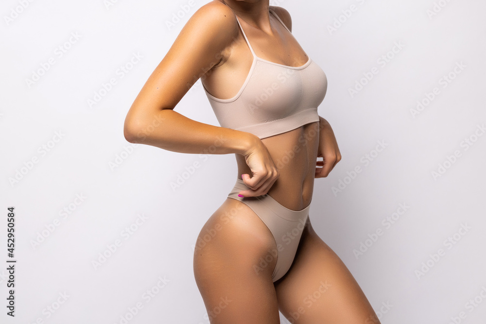 © F8 \ Suport Ukraine - Result of sport and diet. Cropped portrait of young lady in white underwear demonstrating flat stomach and slender legs © F8 \ Suport Ukraine - Result of sport and diet. Cropped portrait of young lady in white underwear demonstrating flat stomach and slender legs