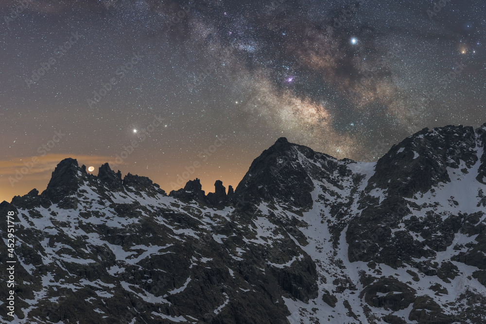 Milky Way in starry sky above snowy mountain at night