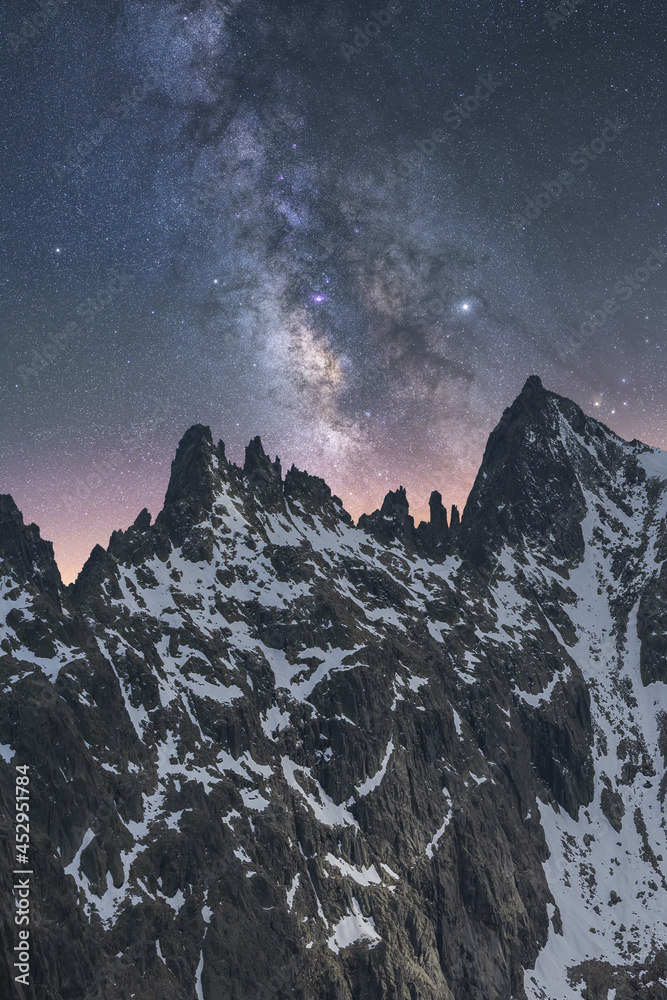 Milky Way in starry sky above snowy mountain at night