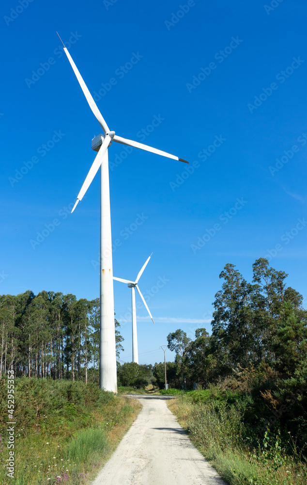 Wind and renewable energy masts with their large propellers and turbines in a rural area in the north of Spain. Alternative and renewable energy concept. . High quality photo Wind and renewable energy masts with their large propellers and turbines in a rural area in the north of Spain. Alternative and renewable energy concept. . High quality photo