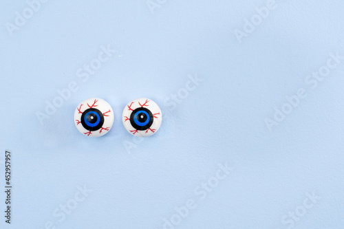 Floating bloodshot eye balls on a blue wall with advertisement copy space