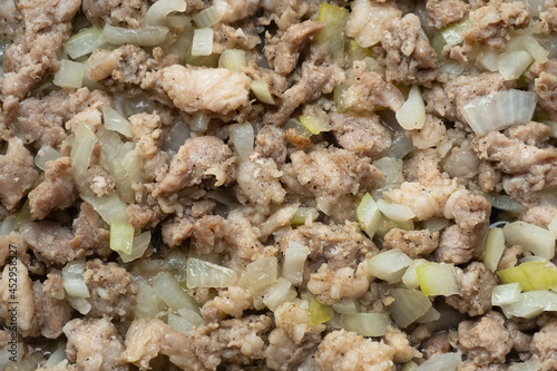 fried minced meat with onions in a frying pan, finely chopped meat background.