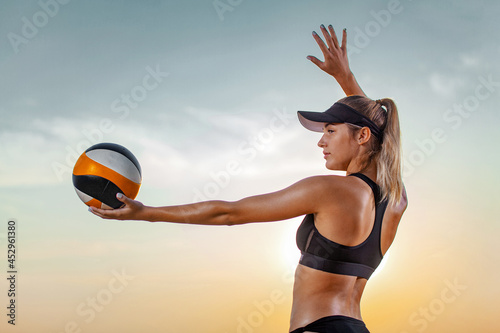 Photography Girl athlete volleyball player on the beach playing at sunset