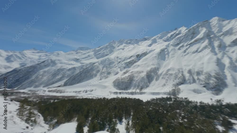Aerial upstairs view from above snow wild walley surrounded by winter landscape cinematic mountain. Fast flying fpv drone mountaineering resort at cliff winter freeride extreme sport activity Aerial upstairs view from above snow wild walley surrounded by winter landscape cinematic mountain. Fast flying fpv drone mountaineering resort at cliff winter freeride extreme sport activity