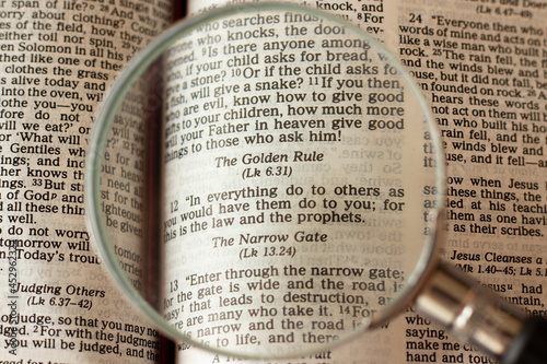 Christian golden rule. Second great commandment. Treat others as you want to be treated. Jesus Christ's teaching of relationship.Magnifying glass over open Holy Bible Book. A closeup. Biblical concept