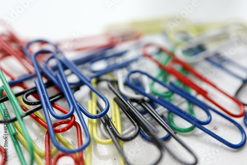 bunch of multicolored colorful paper clips on a white table background
