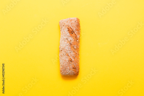 Bread, pastries on a colored bright background. Bread with sesame seeds and seeds, bread texture. Delicious flavored bun.