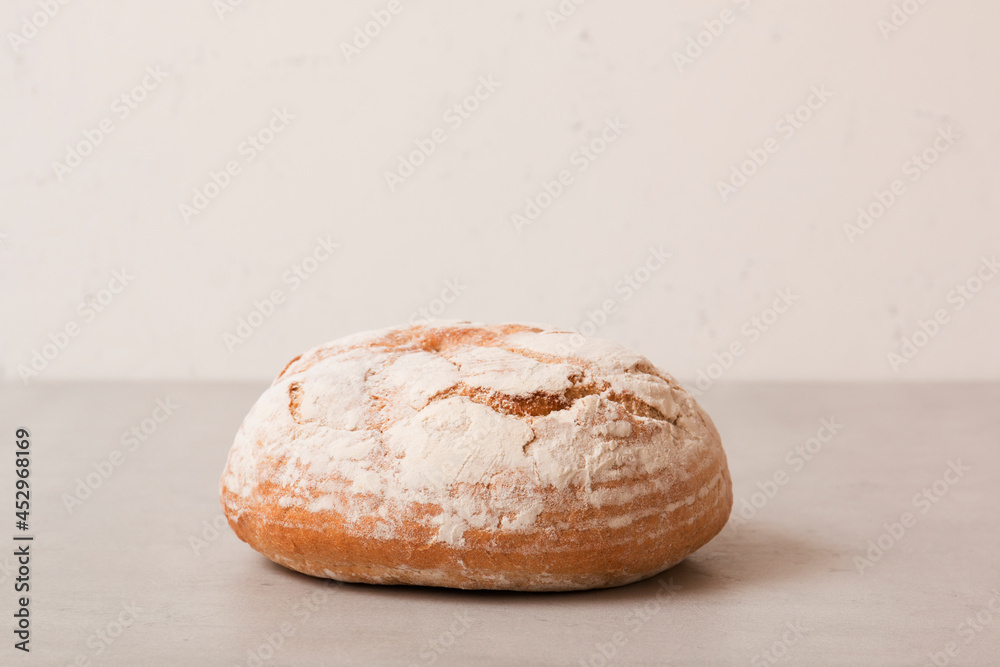 Soft fresh round bread on a light background. Fragrant pastries.