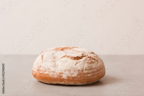 Soft fresh round bread on a light background. Fragrant pastries.