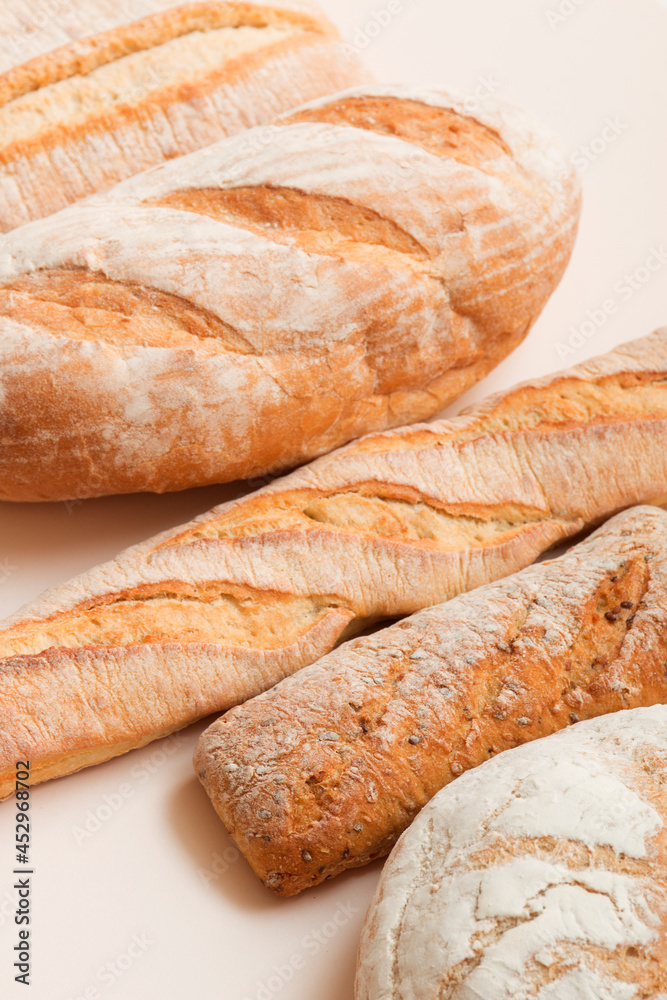 Lots of different fresh breads on a light background. Fragrant airy baked goods. Sliced ​​bread.
