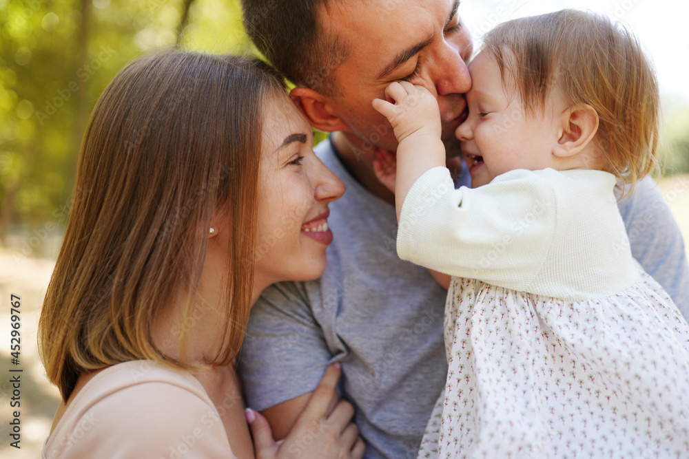 Happy young family spending time together, mother and father with baby outside in green nature. Happy young family spending time together, mother and father with baby outside in green nature.