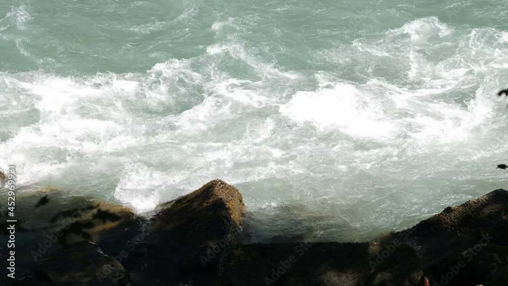 Wild furious mountain river flowing through stone boulders. Cold water splashing near rapids. Clean cold water hits stones with many splashes. 4 k video Wild furious mountain river flowing through stone boulders. Cold water splashing near rapids. Clean cold water hits stones with many splashes. 4 k video