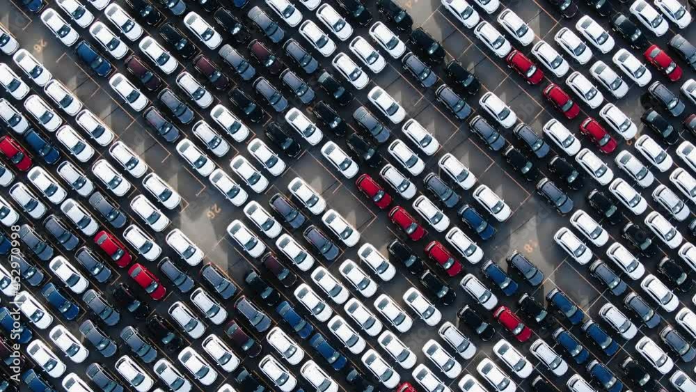 Long rows of finished white black red and blue automobiles on open warehouse parking lot of car factory giant aerial view Long rows of finished white black red and blue automobiles on open warehouse parking lot of car factory giant aerial view