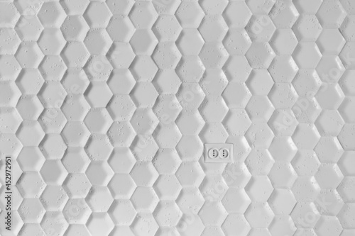 Fototapeta Naklejka Na Ścianę i Meble -  electrical outlet on the wall of white tiles in the form of a honeycomb. Gray Hexagon Background wall Texture. wall background.