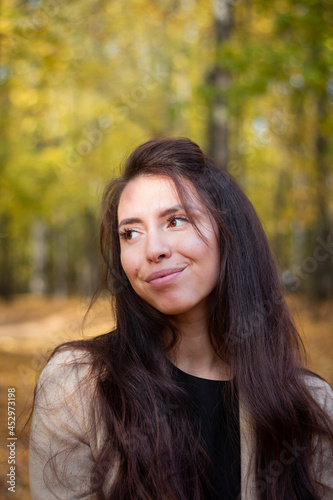 Brunette woman in autumn park. Close plan. Smiling woman. Autumn mood. Beautiful brunette.