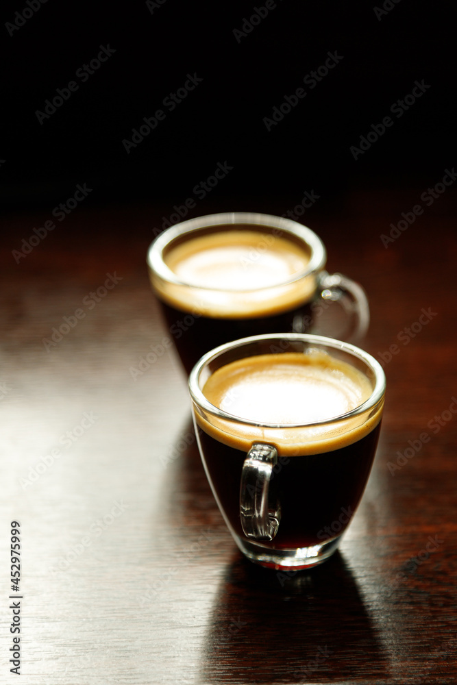 two glass coffee cup with espresso near the window in morning two glass coffee cup with espresso near the window in morning