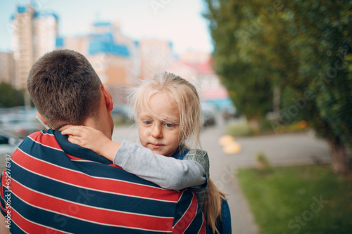 Rear view of father walking to kindergarten with his little daughter photo