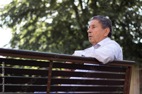 Portrait of senior man sitting on bench. Feeling lonely and pensive