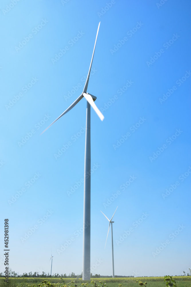Field with huge wind generators against the blue sky Field with huge wind generators against the blue sky